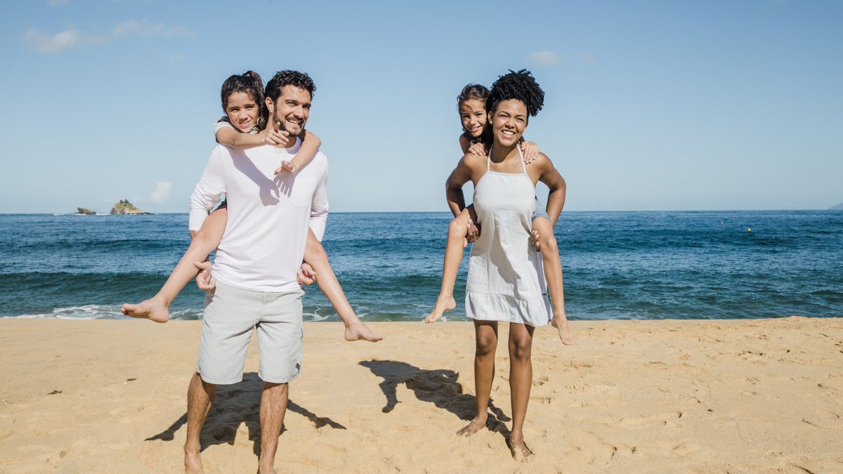 Mom, Dad, and their two children playing at the beach