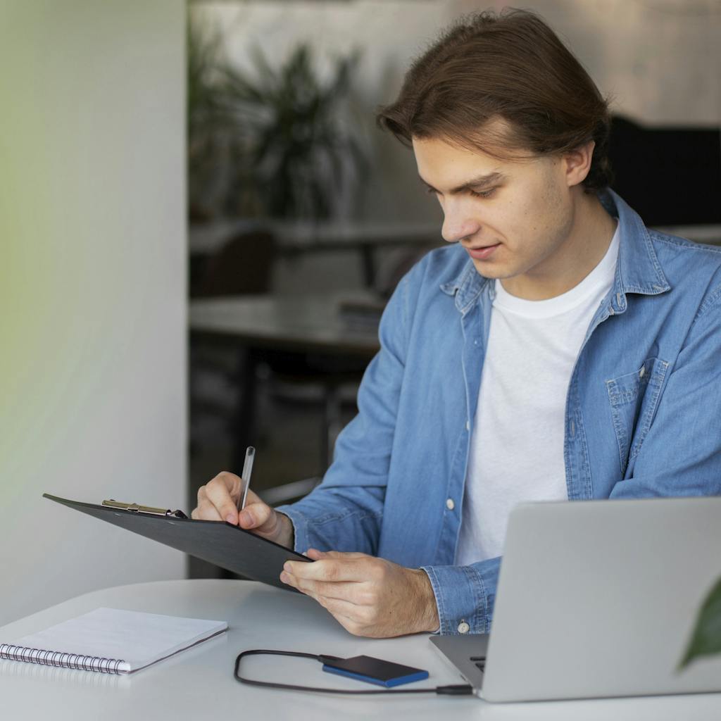 Man using his laptop and taking notes