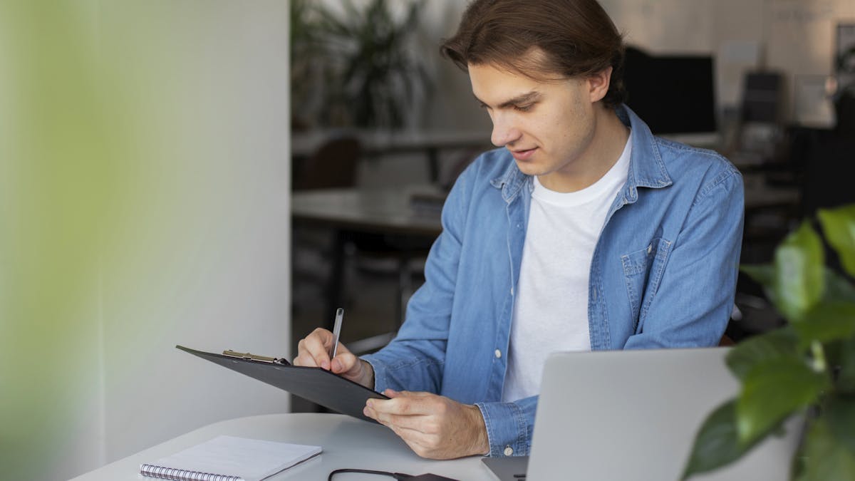 Man using his laptop and taking notes