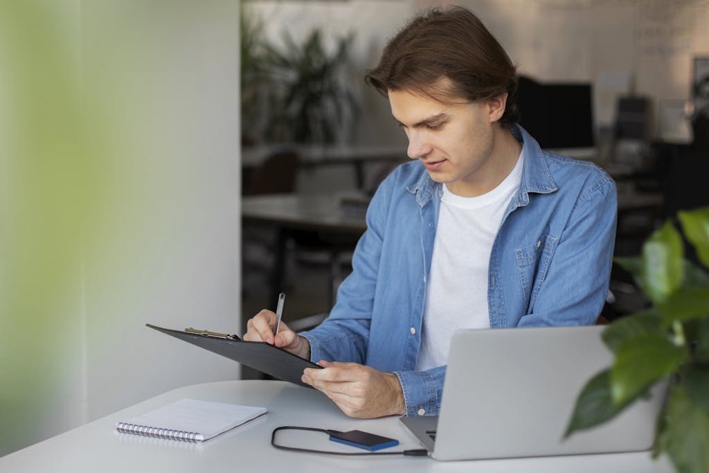 Man using his laptop and taking notes