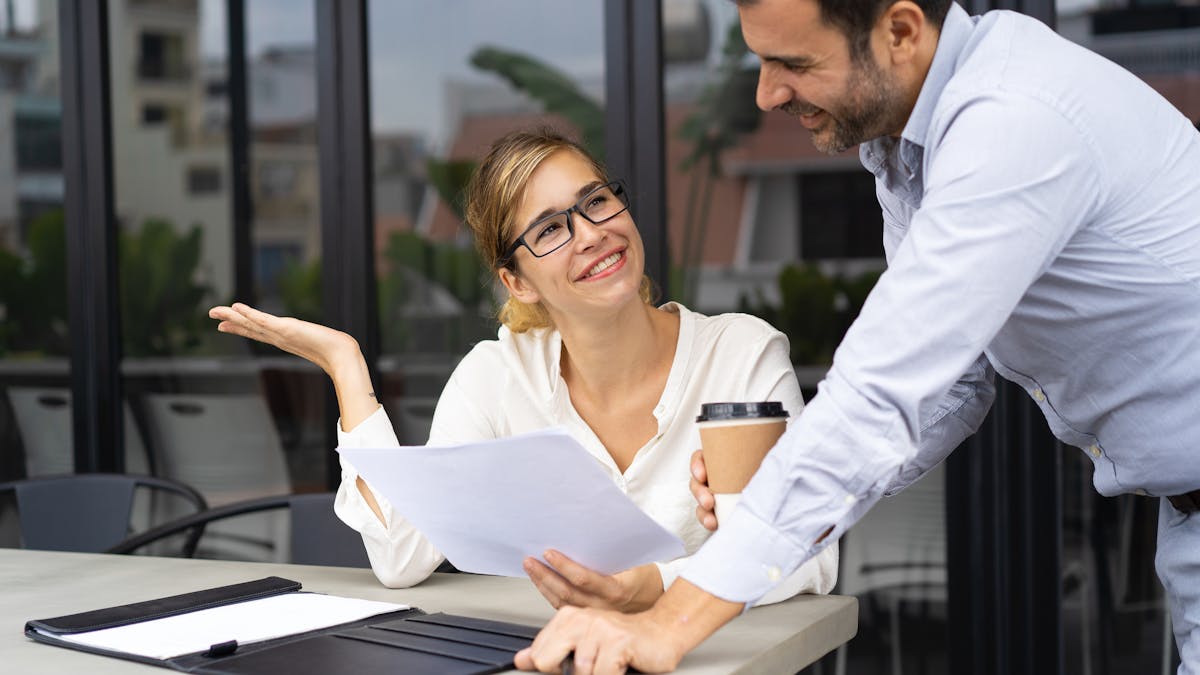 Happy business colleagues discussing papers