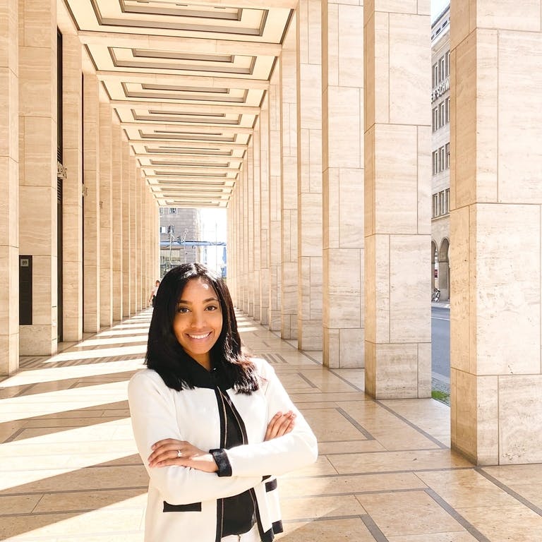 Alexandra stands up in the street with a white suite