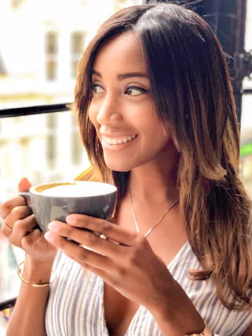 Alexandra drinking a cup of coffee looking through the window