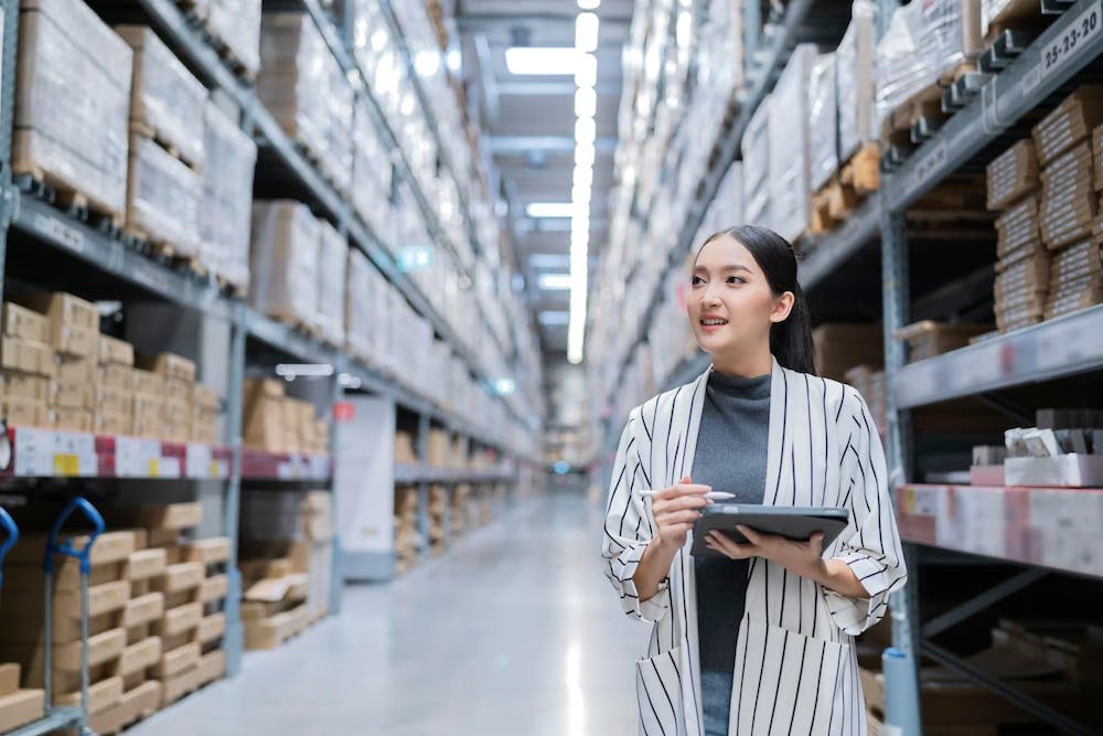 Portrait of asian woman business owner using digital tablet checking amount of stock product inventory on shelf at warehouse. <a href="https://www.freepik.com/free-photo/portrait-asian-woman-business-owner-using-digital-tablet-checking-amount-stock-product-inventory-shelf-distribution-warehouse-factorylogistic-business-shipping-delivery-service_25192338.htm#query=business%20export%20owner&position=32&from_view=search&track=ais">Image by Lifestylememory</a> on Freepik