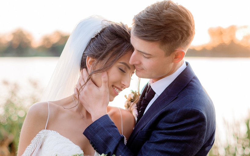 Pareja en ceremonia de matrimonio, abrazándose y sonriendo 