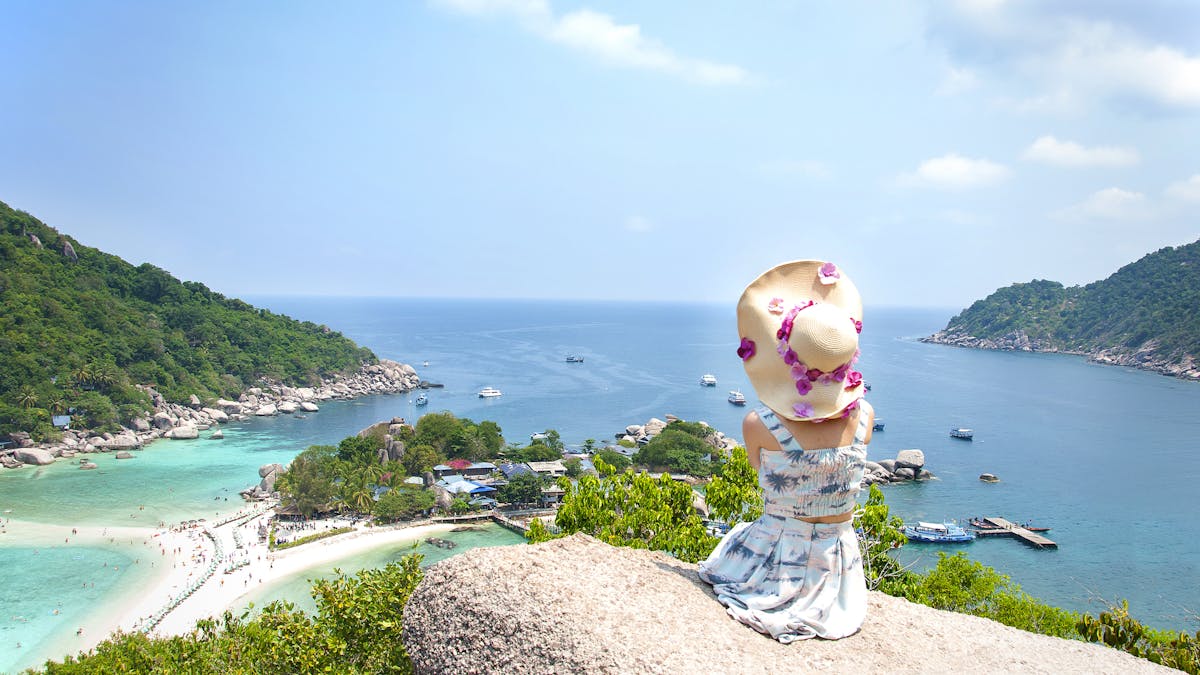 Chica mirando la playa desde una colina