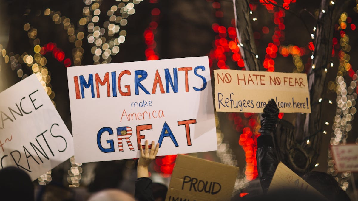 People protesting with banners and slogans supporting immigration