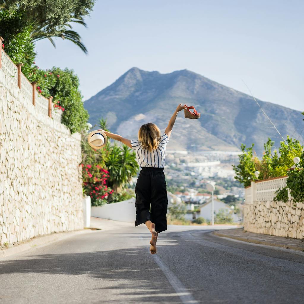 Girl happily jumping in the middle of the street