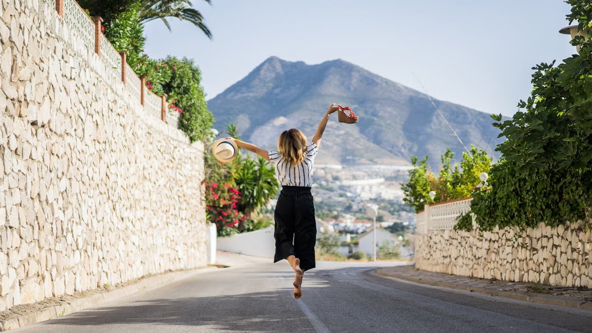 Girl happily jumping in the middle of the street