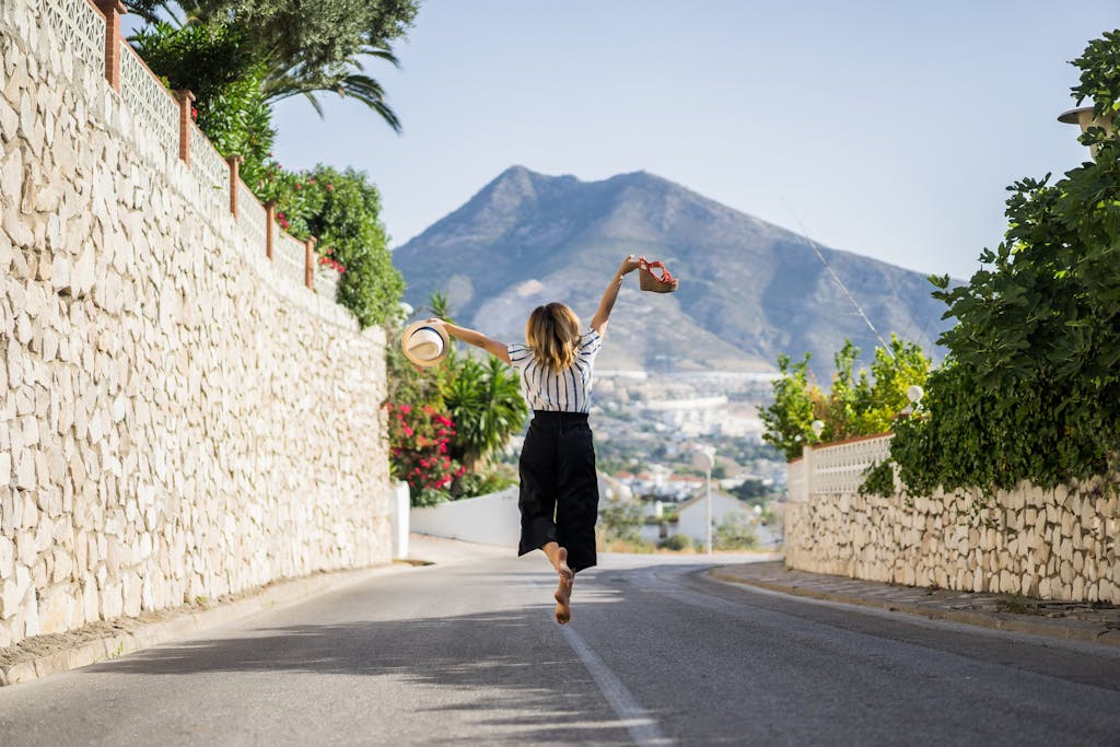 Girl happily jumping in the middle of the street