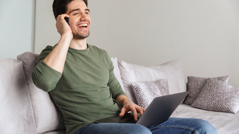 Smiling young man talking on mobile phone