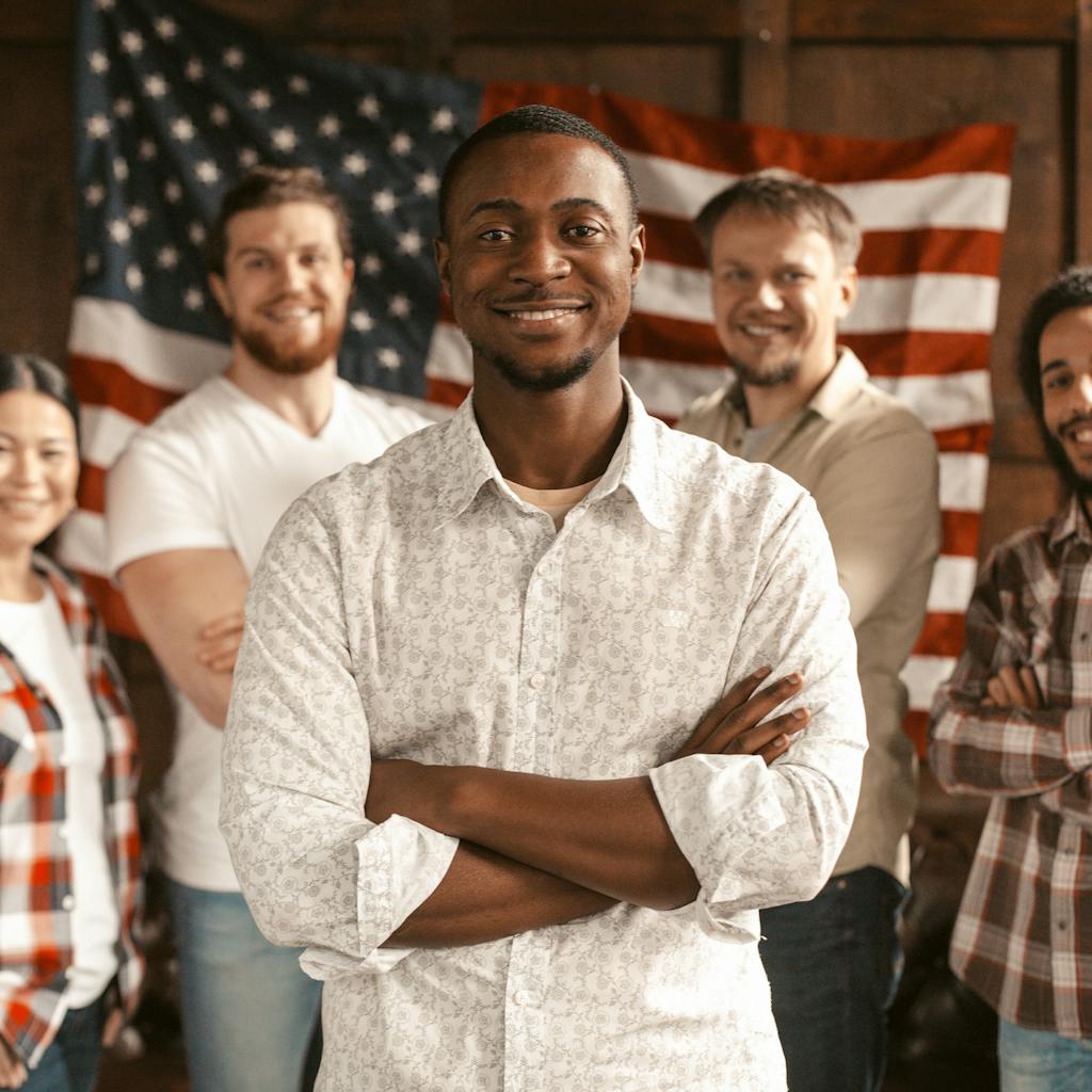 Diverse group of Americans standing  in front of an American flag 