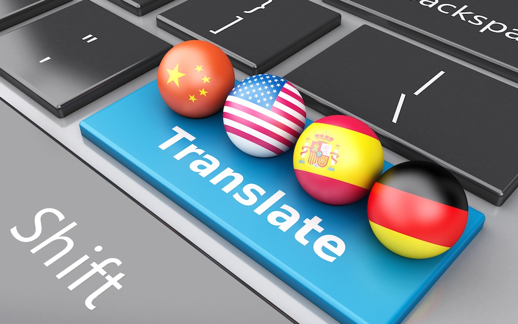 Keyboard with Translate key and flag pins laying on top. 