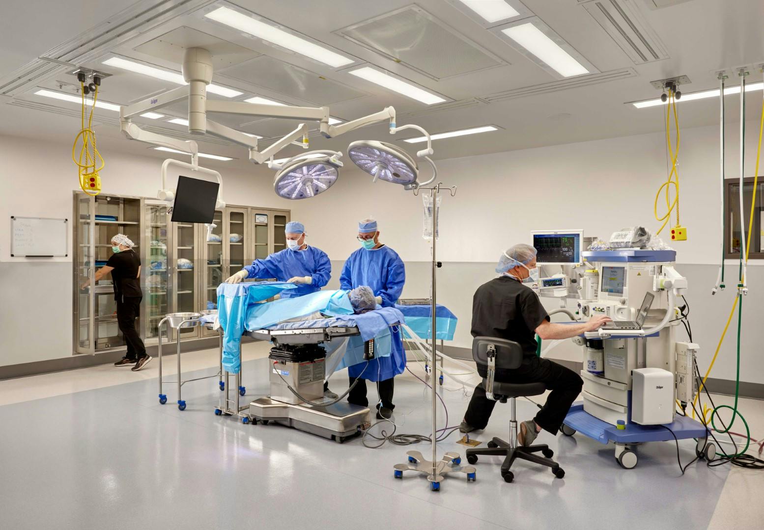 The OR of the OOC ambulatory surgery center. Shows three doctors in the room and a patient on the operating table. 
