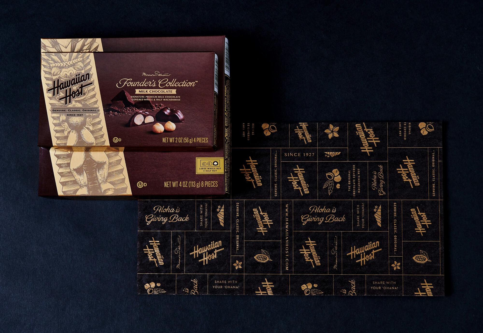 A smaller Founder's Collection Milk Chocolate Box closed on top of a large box. Beneath reveals the insert under the box's cover with a gold pattern printed on it.