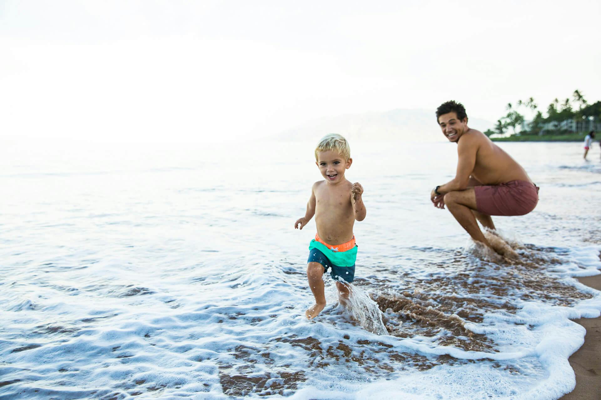 Lifestyle photograph of father and son on beach 