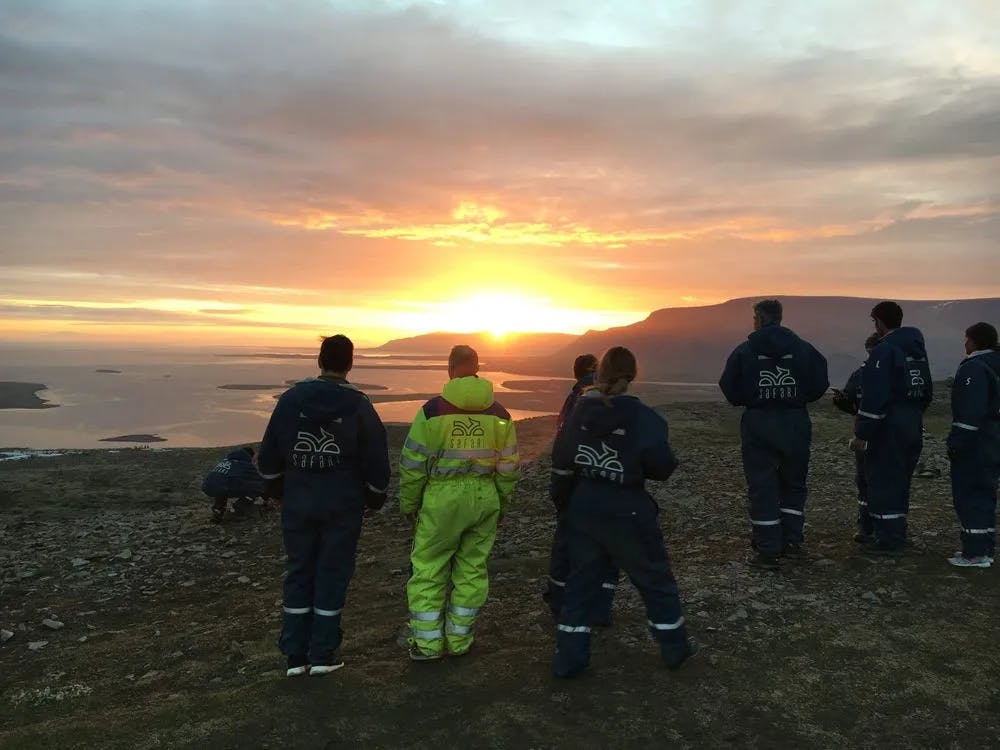 Group of Tourists Captivated by Ocean Sunset on Iceland ATV Tour