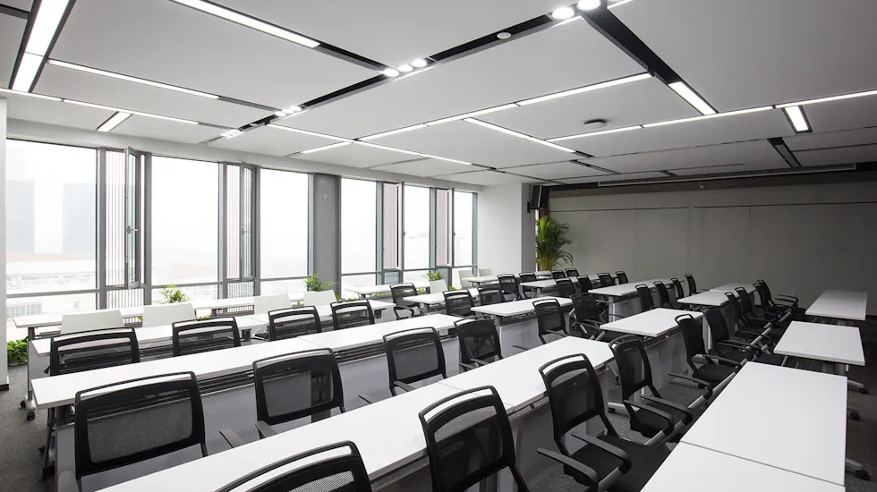 Bright empty training classroom with rows of desks