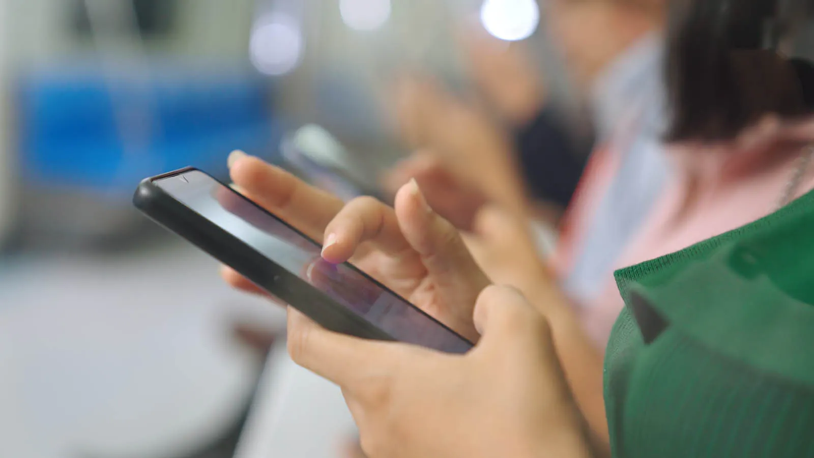 Commuters on a train using their phones