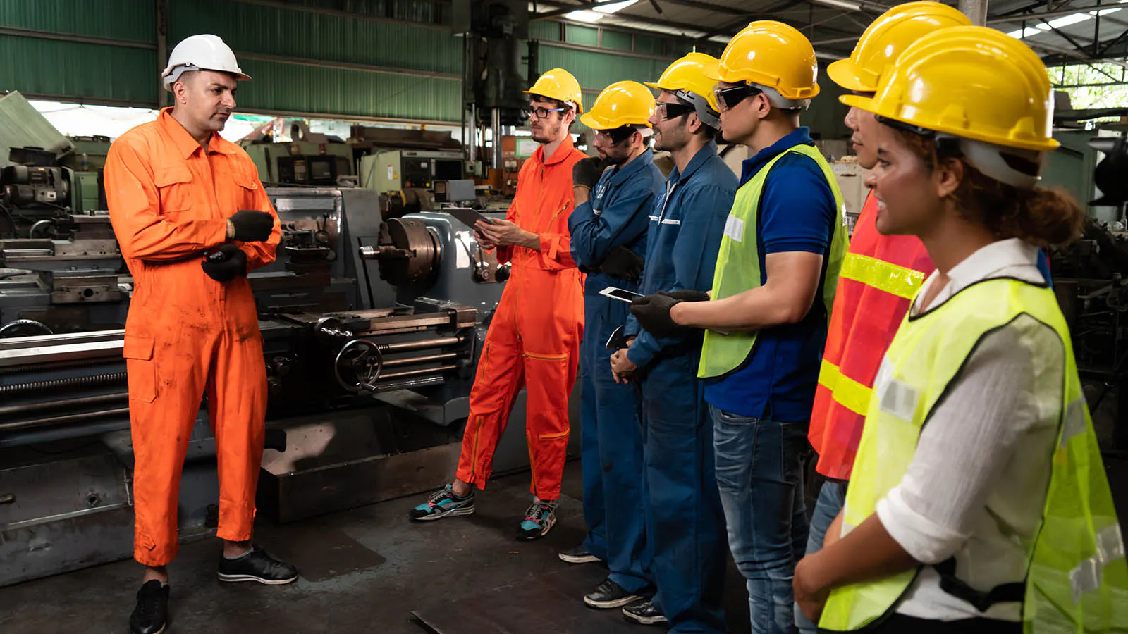 Safety manager leading a monthly safety training briefing with factory workers