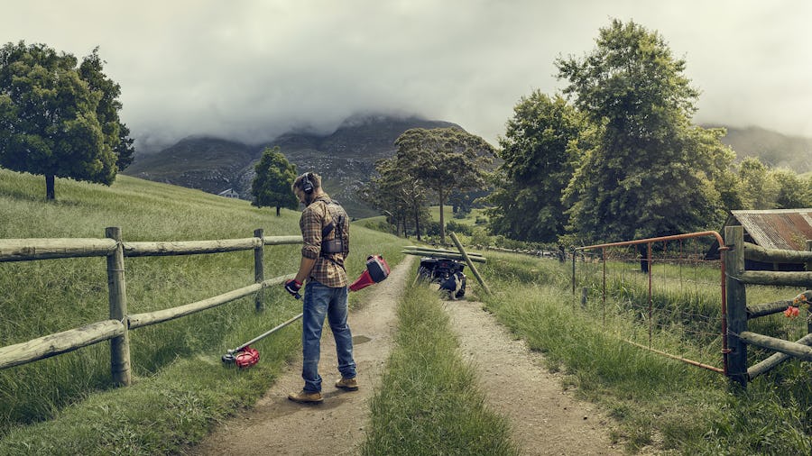 En man som står på en stig med en gräsklippare och ett staket, varumärkesbilder för Jonsered, gjord av Saga Production