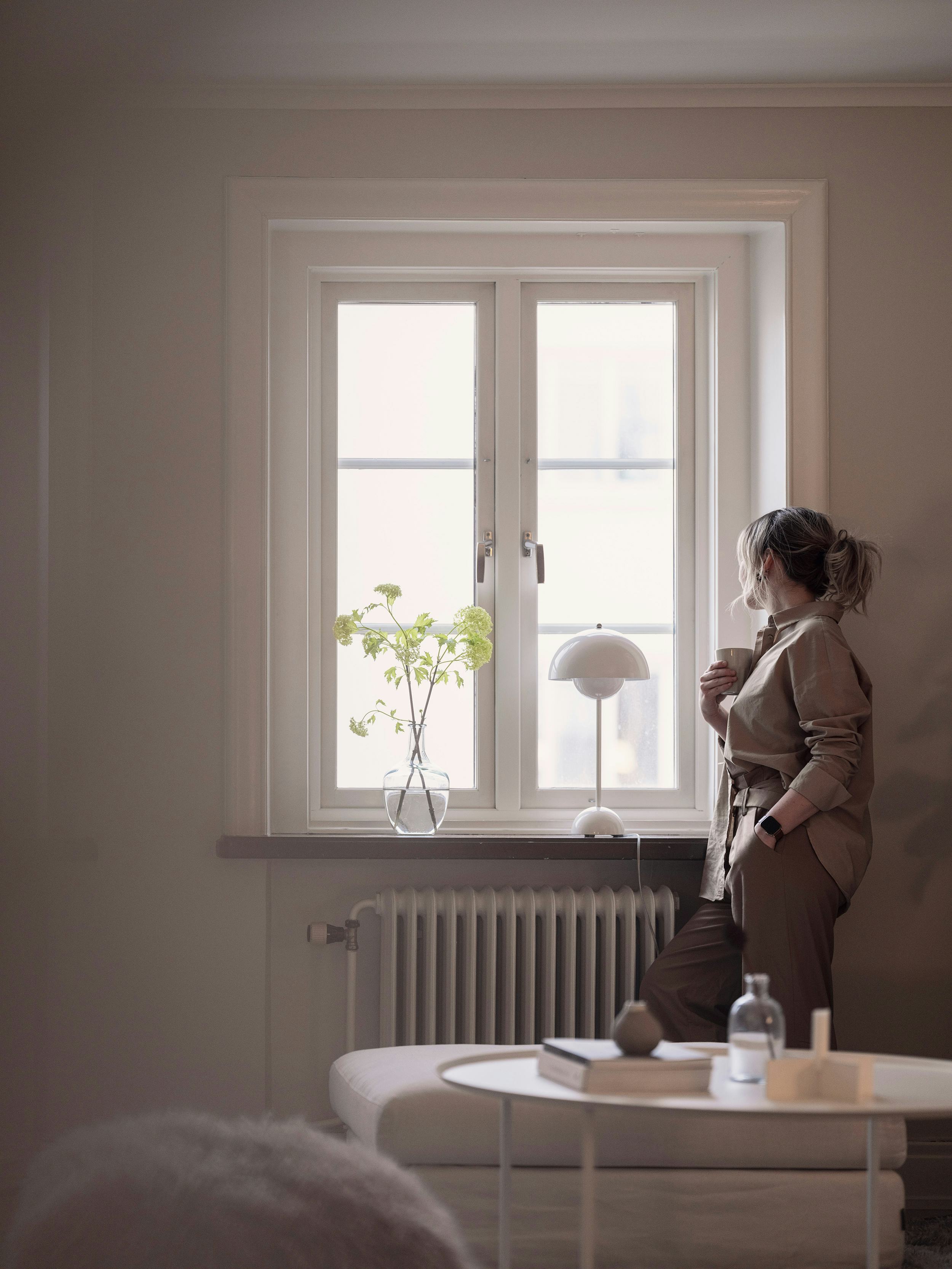 Kvinna tittar ut genom fönster - Acticon varumärkesbild av Saga Production