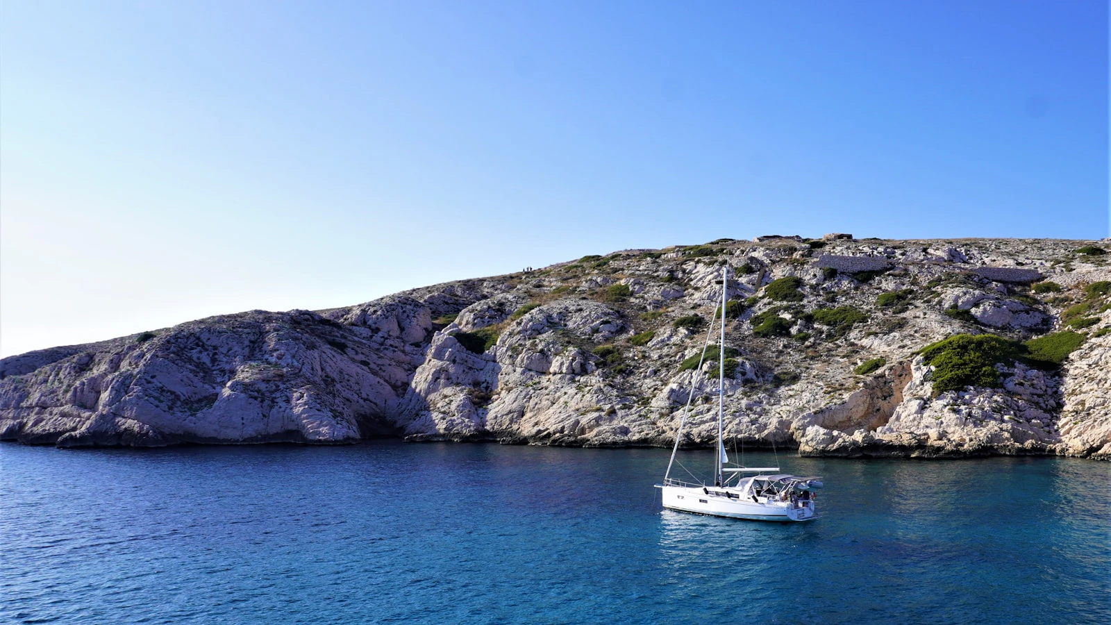 Sailboat beside a rocky Adriatic island coastline