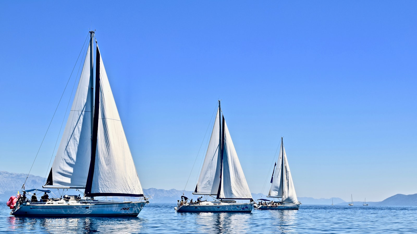 Three sailboats sailing on open Adriatic water