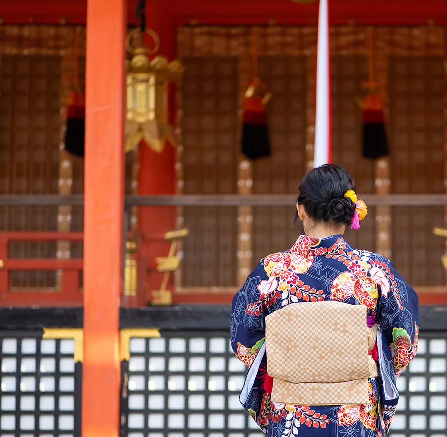 A woman in a kimono prays at a shrine for the New Year