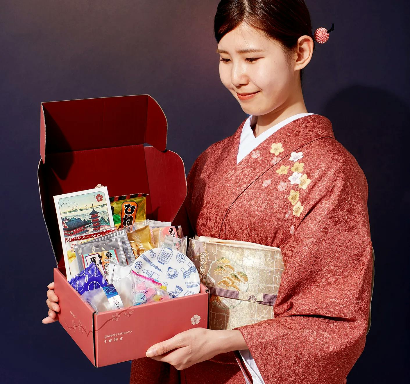 A woman in a kimono holds Sakuraco's June box