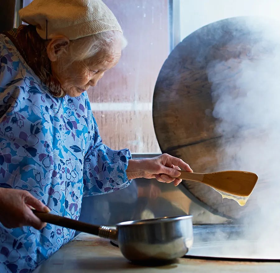 An elder Japanese woman crafts rice candy, a tradition that has been passed down for 500 years.