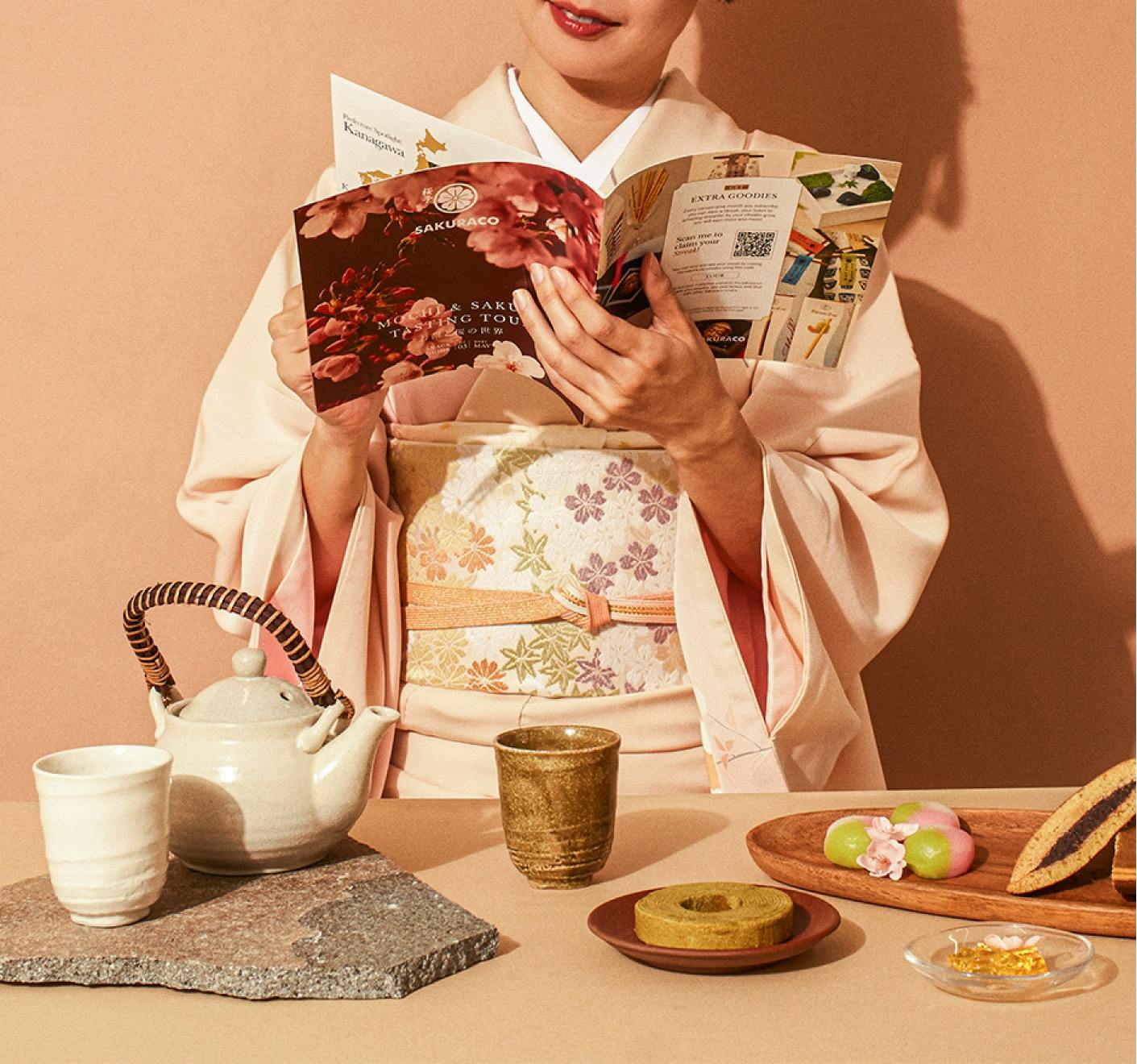 Ayumi Chikamoto (Sakuraco's CEO) stands in a kimono reading Sakuraco's culture guide