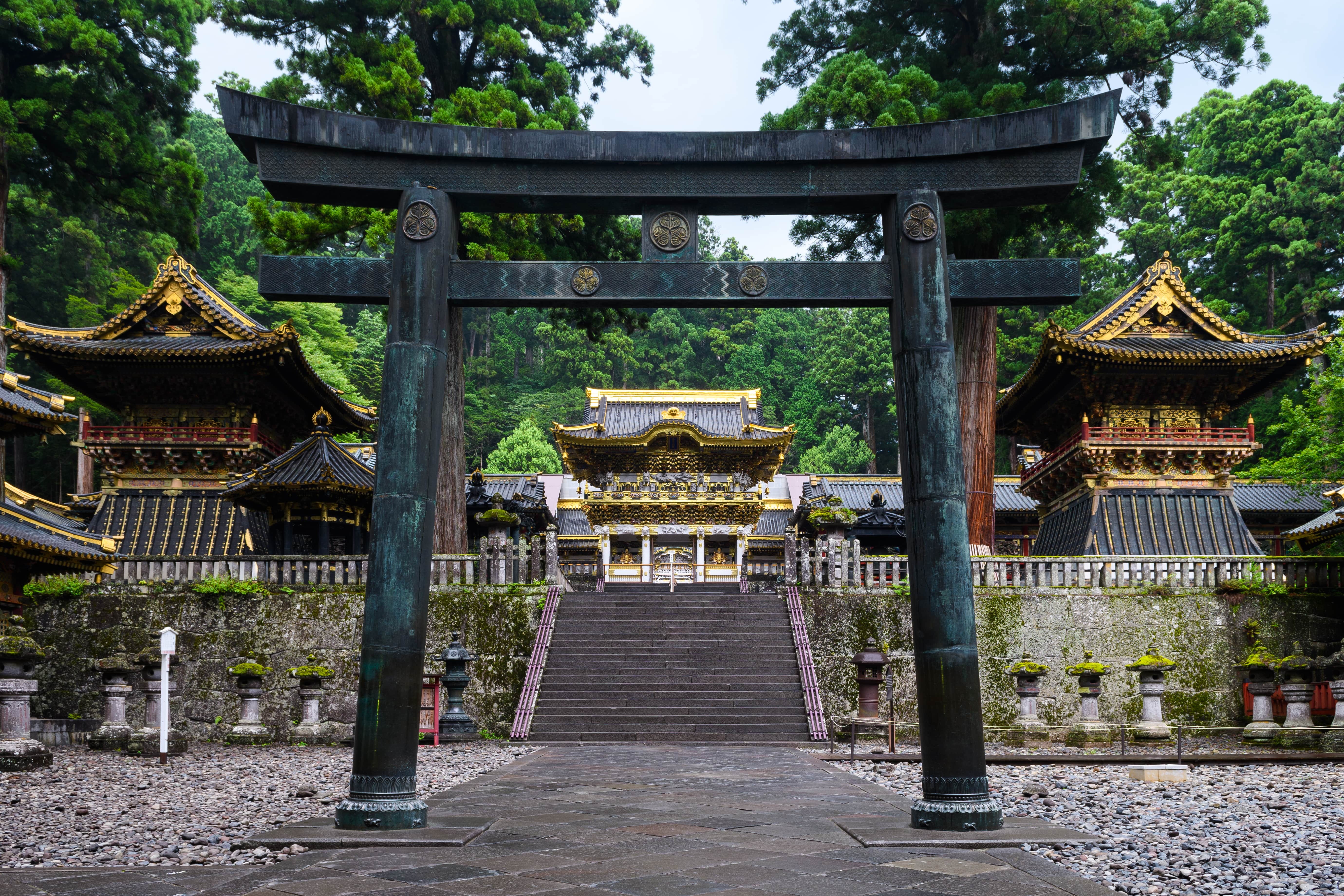 A grey torii gate is shown in front og Nikko's Toshogu Shrine in Tochigi prefecture.