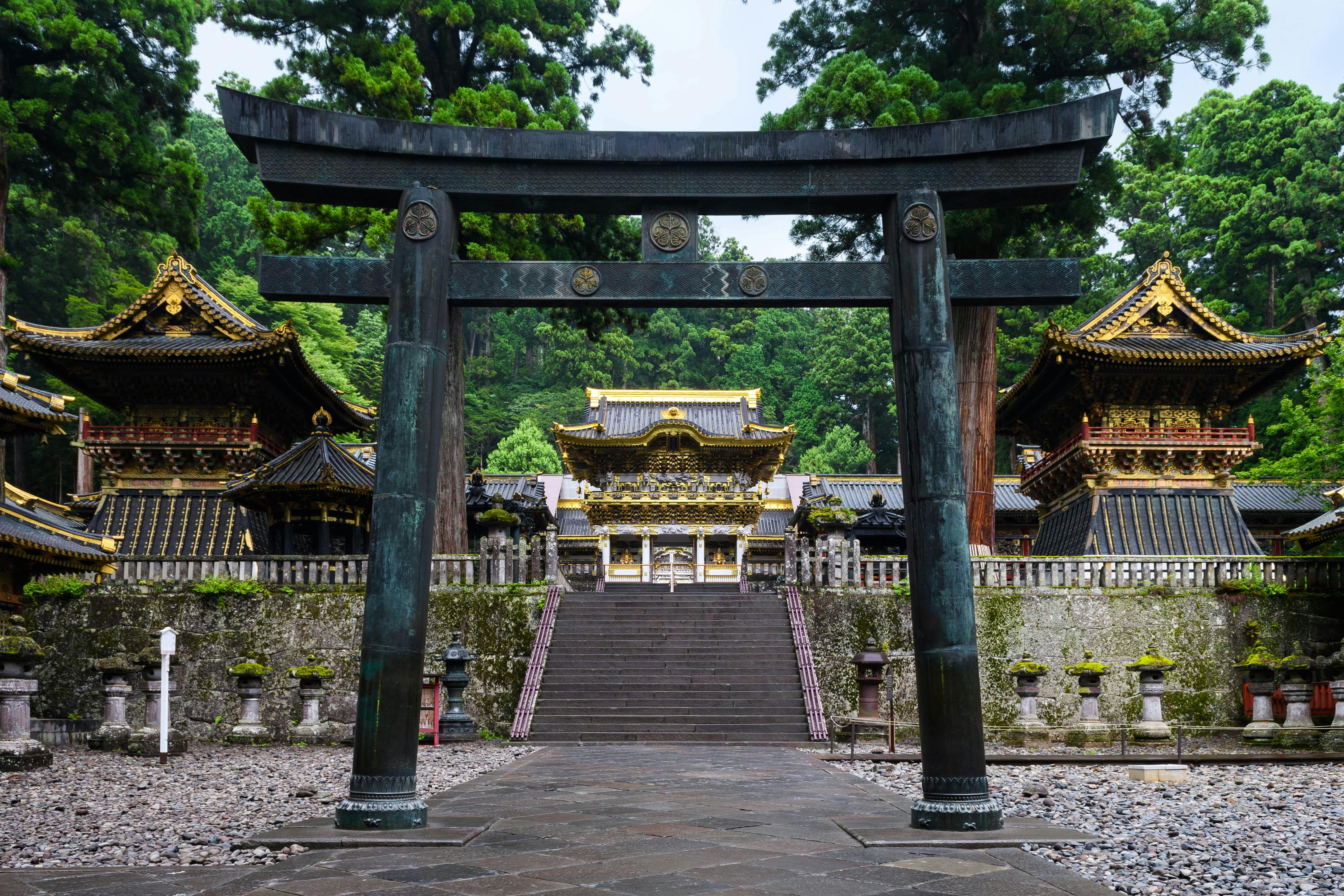 A grey torii gate is shown in front og Nikko's Toshogu Shrine in Tochigi prefecture.