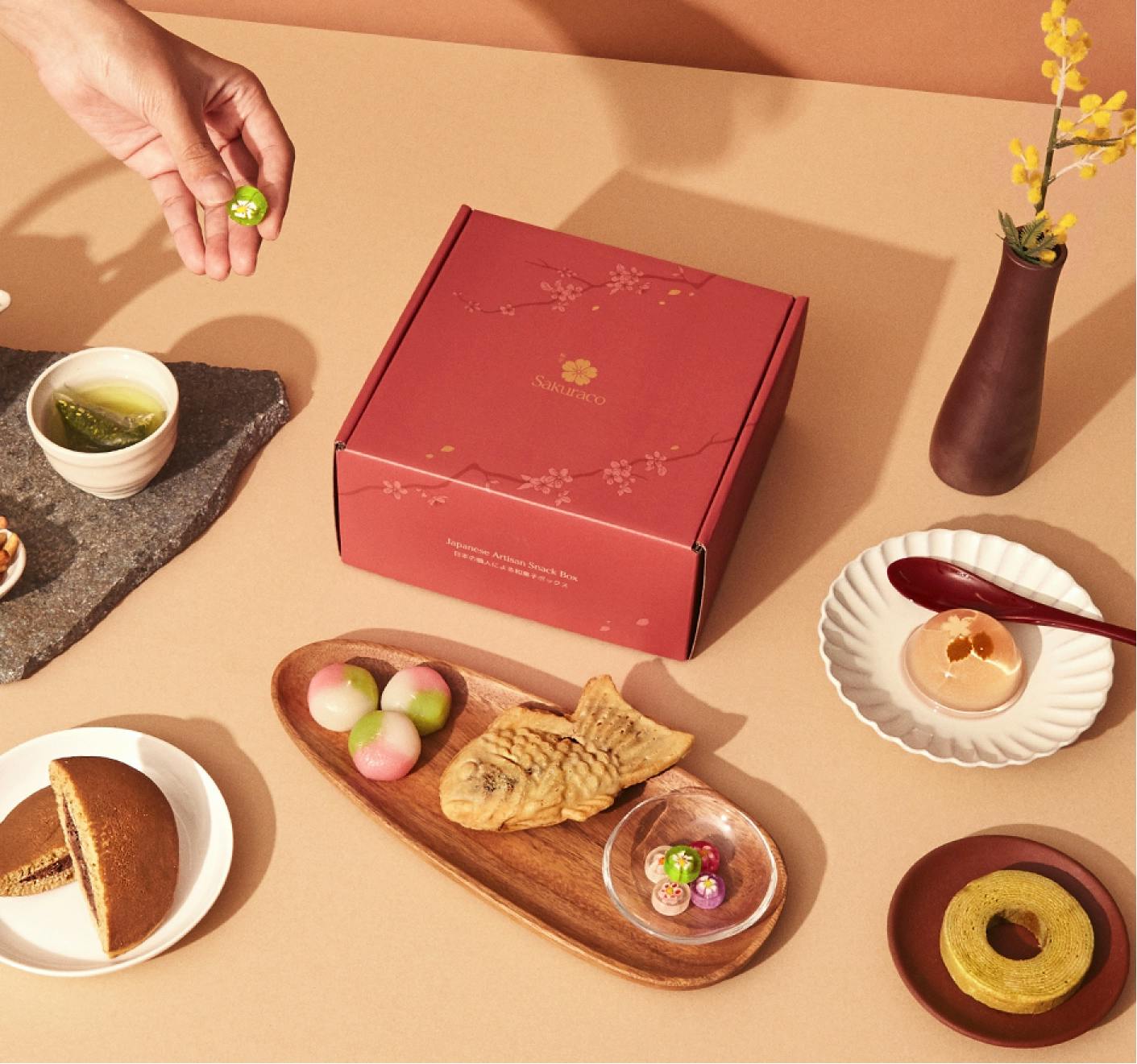 A Sakuraco snack box surrounded by delectable traditional snacks
