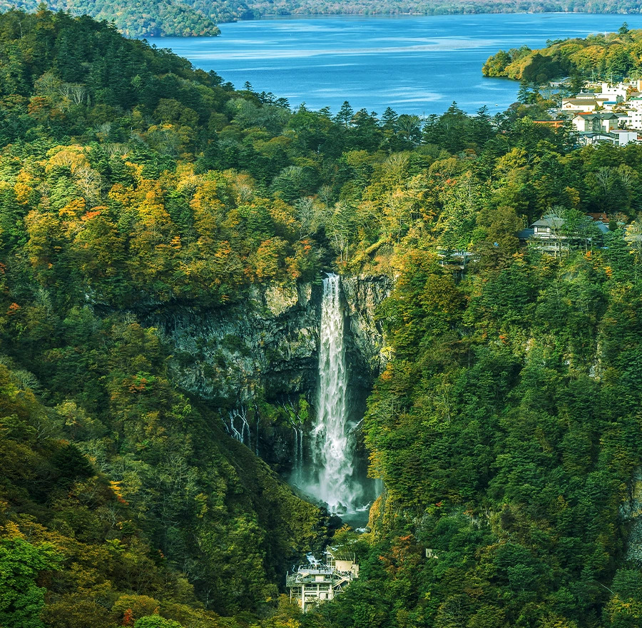 An aerial shot of kegon falls spilling out from chuzenji lake
