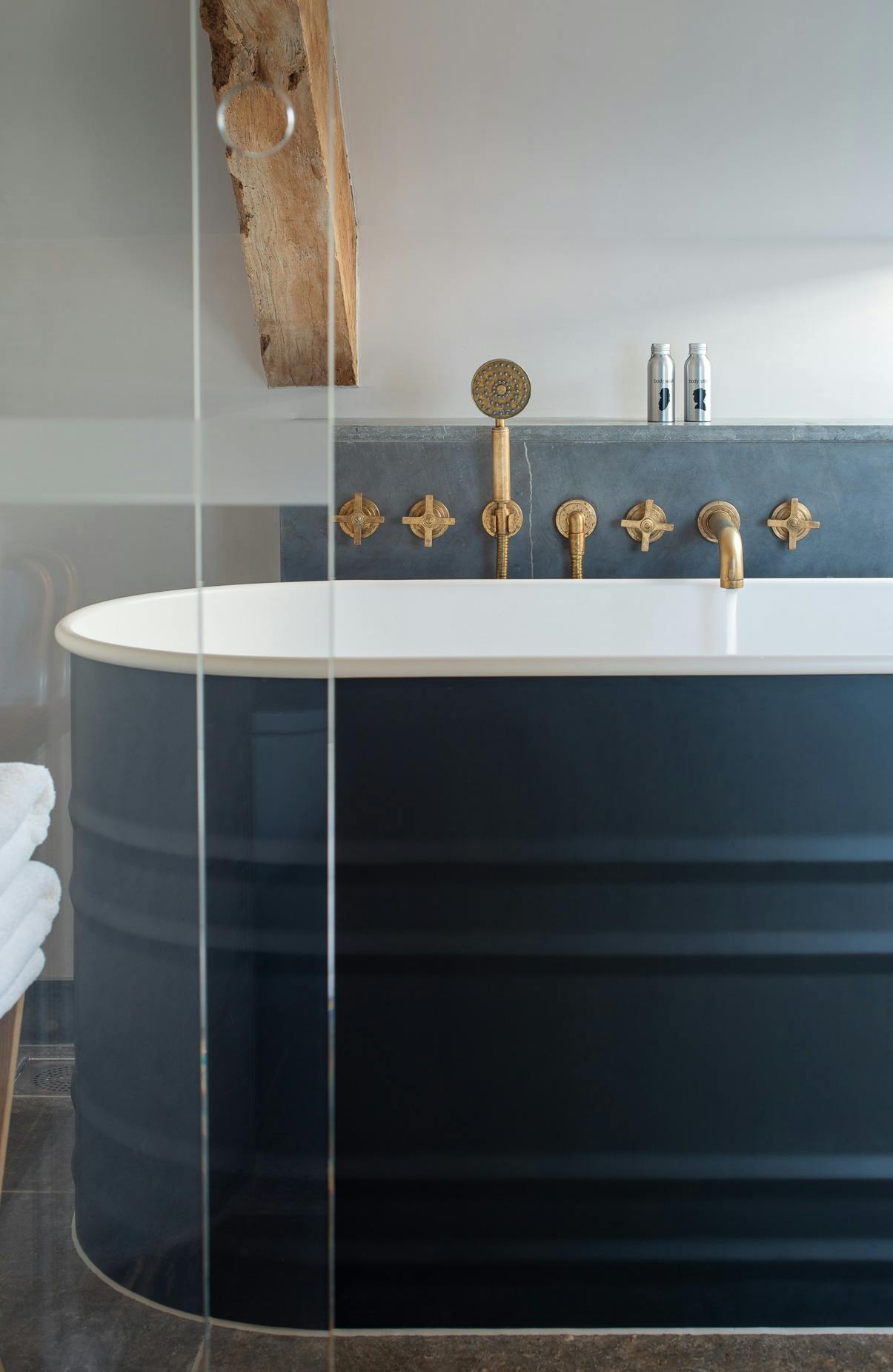 Samuel Heath Bauhaus inspired Landmark Pure wall mounted bath and shower filler in a natural urban brass finish showing patina.