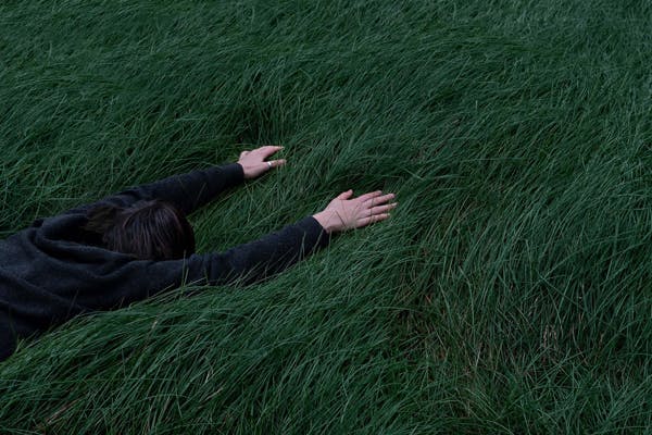 man on grass trying to regulate core temperature for sleeping