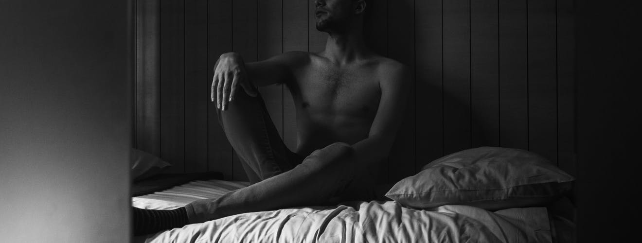 man sitting on bed - how to stop night sweats in men