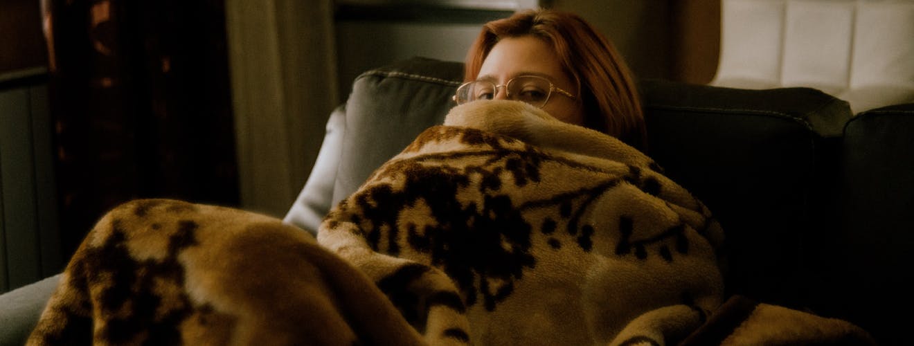 woman hiding under covers - is insomnia genetic?