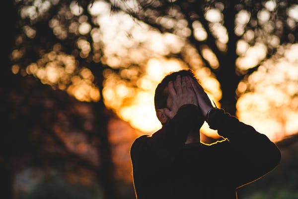 man covering his face - insomnia, genetic