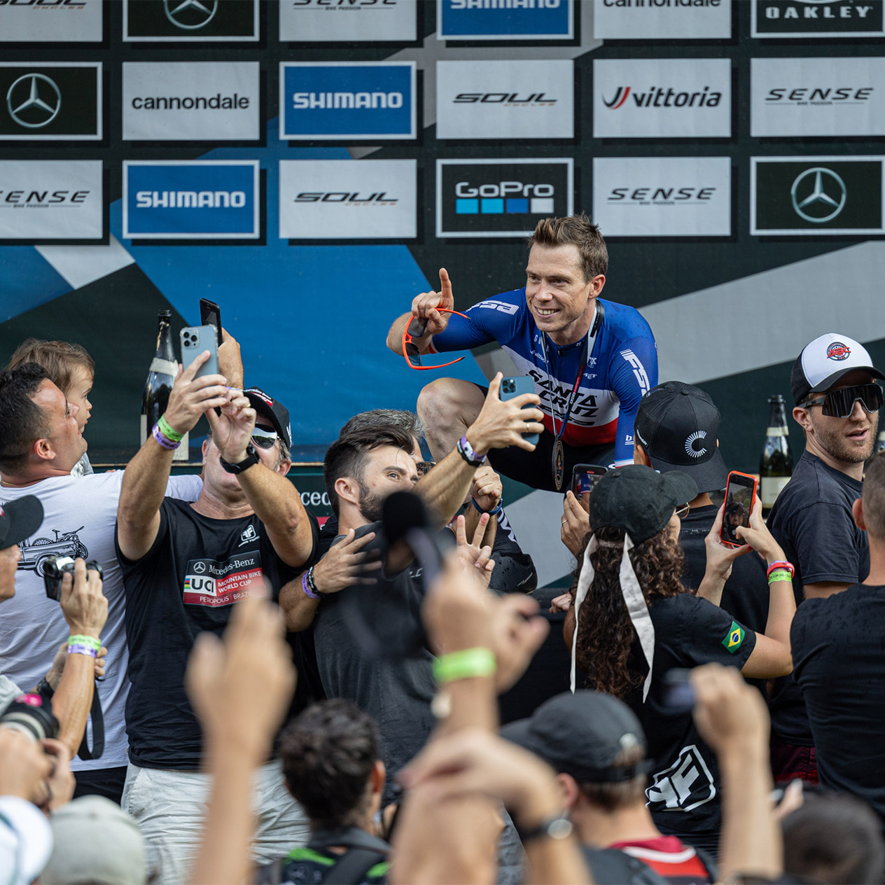 Maxime Marotte taking photos with fans on the podium after a race