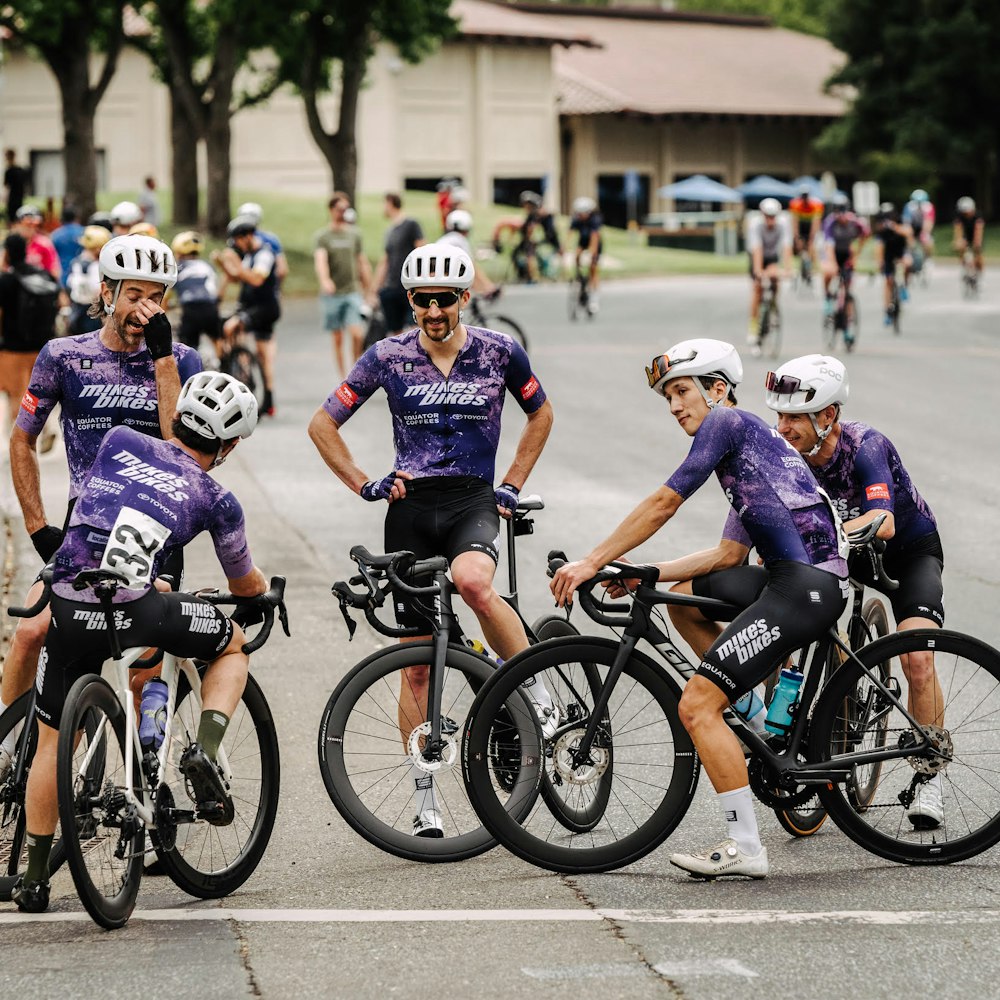 5 members of Mike’s Bikes-Equator Coffee Road Race Team sitting on their bikes and chatting