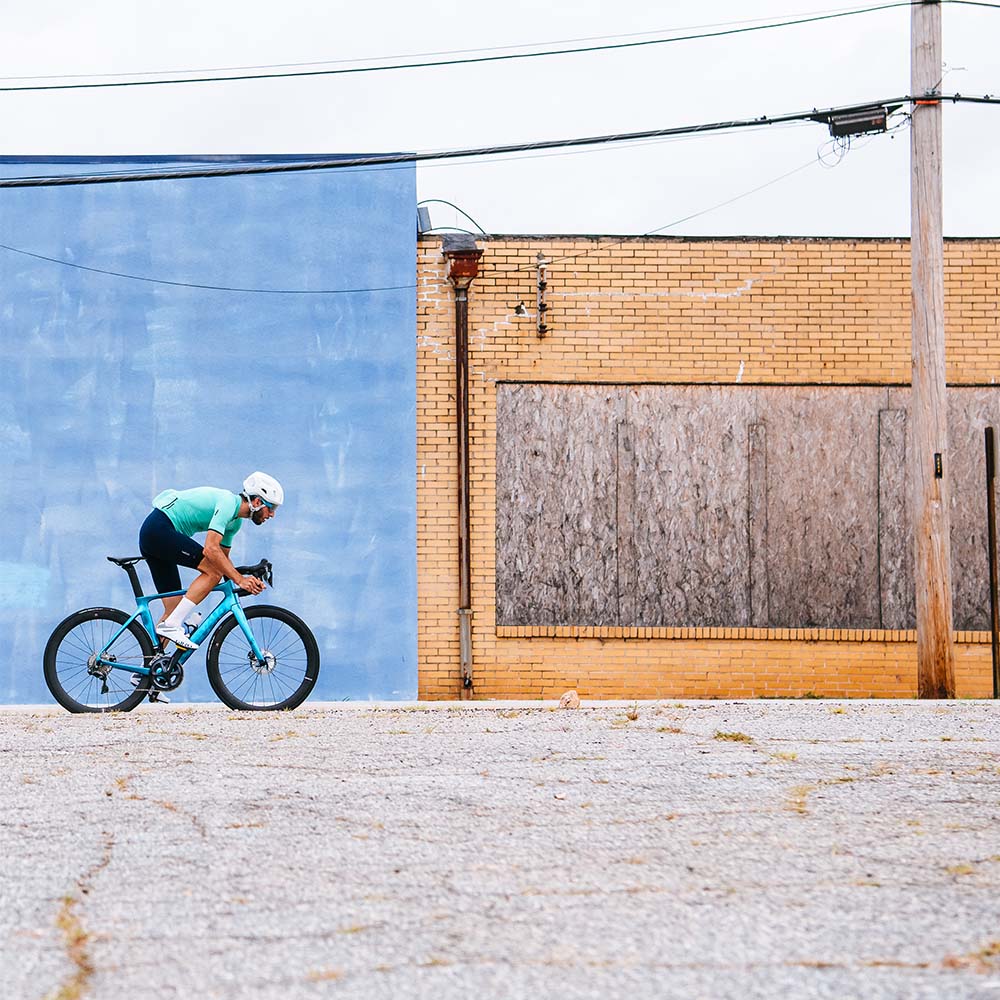 Cyclist in blue jersey riding aero bike wheels