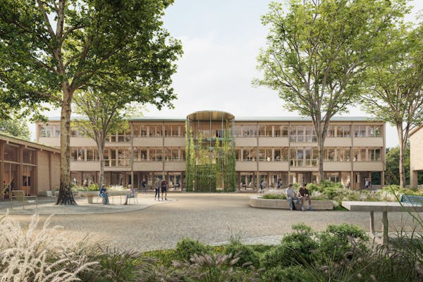 Blick vom Innenhof auf das neue, riegelförmige Gebäude, das sensibel in den bestehenden Campus eingefügt wurde.