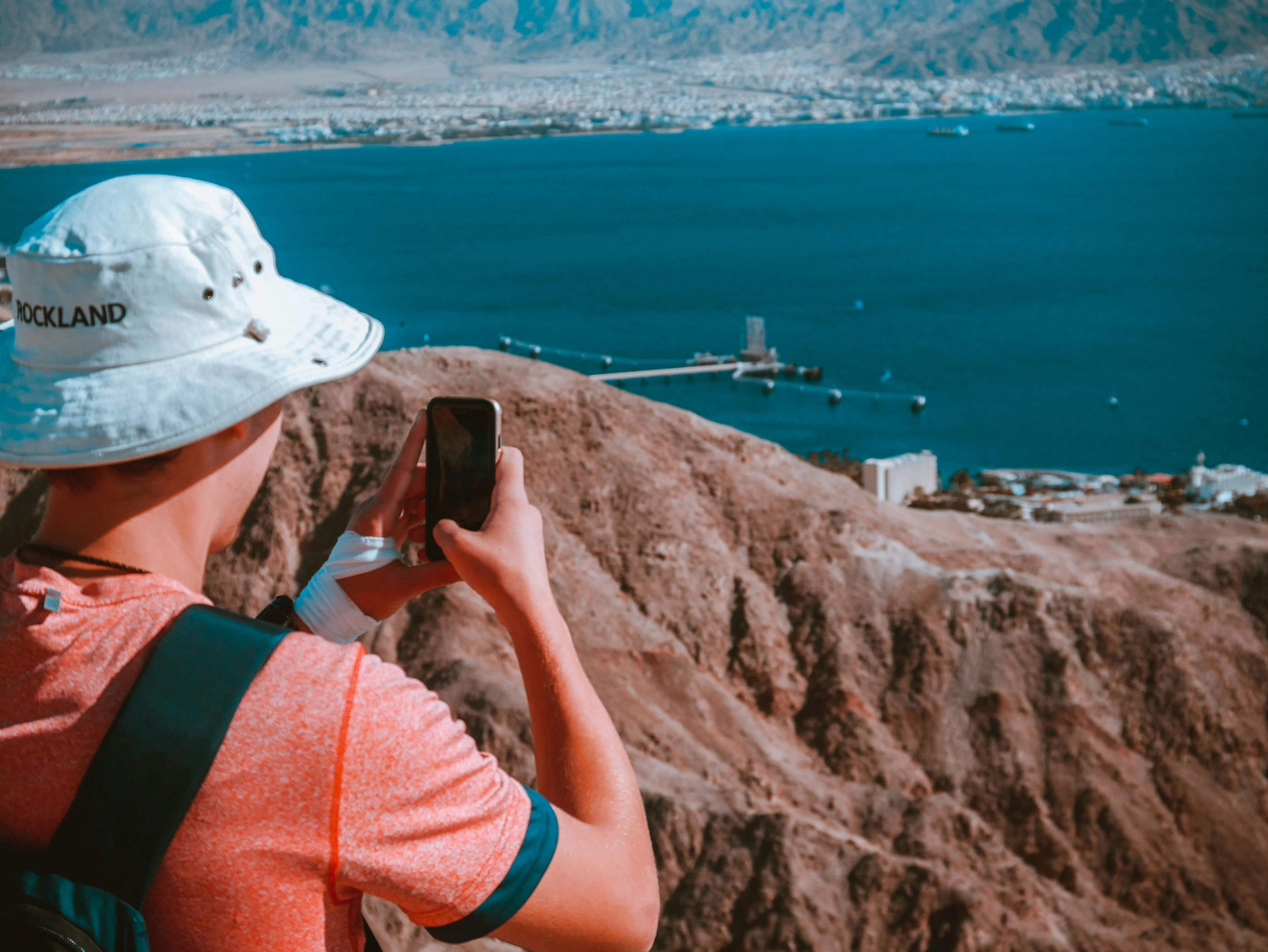 Man taking picture with phone of Eilat city.