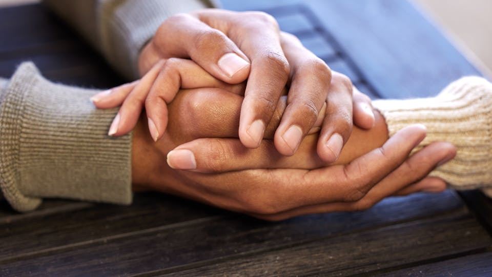 couple holding hands outdoor with help, support and hope in crisis.