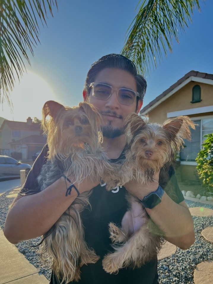 Saul holding two yorkshire terrier dogs.