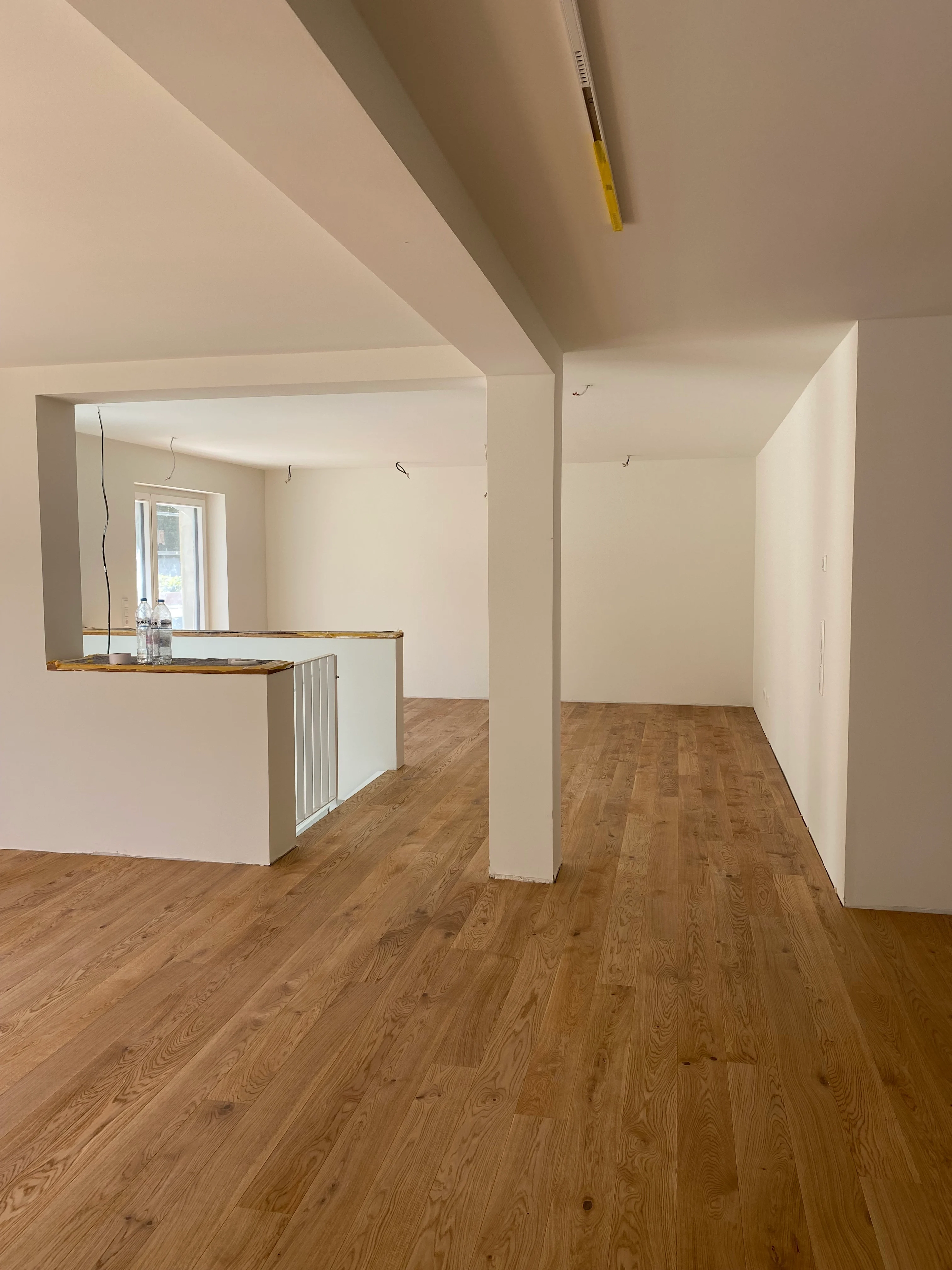 Detaillierte Ansicht des weiß geölten Landhausdielen-Parketts. Man sieht deutlich die präzise Verlegung der Dielen, die nahtlos in das integrierte Treppenpodest übergehen.