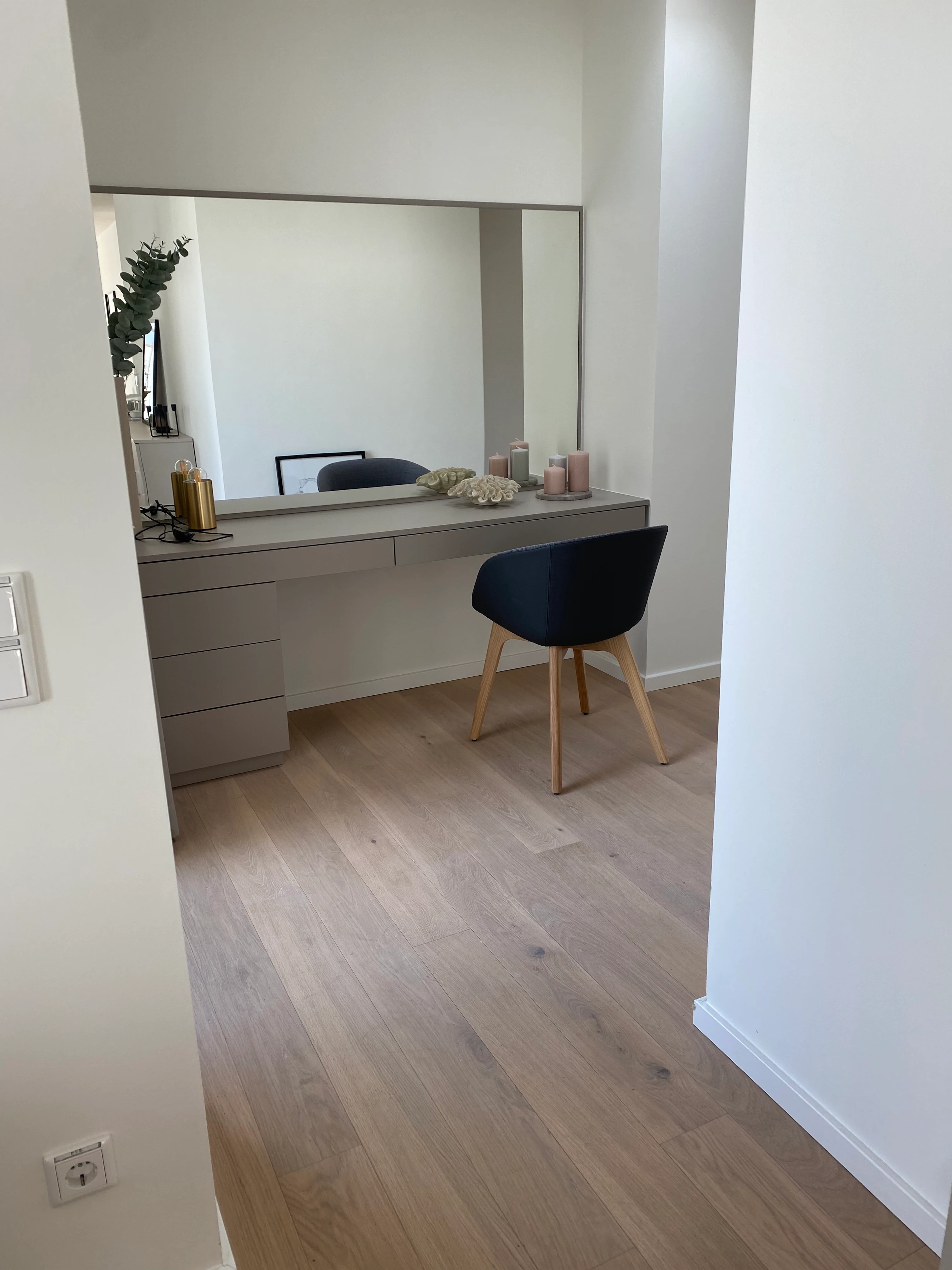 Elegante Nische mit Schminktisch und großem Spiegel, die die durchgehende Verlegung der Bauwerk Landhausdielen zeigt.